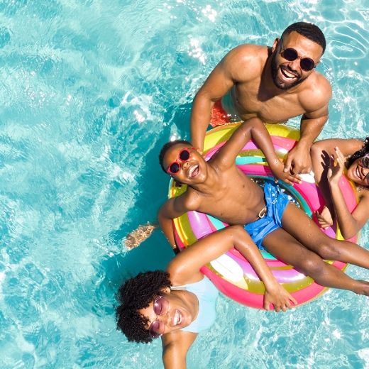 Familie mit buntem Schwimmreifen im Pool Familie mit buntem Schwimmreifen im Pool
